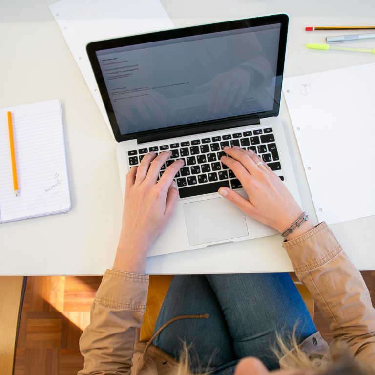 Woman typing on a laptop, representing Kasandra Friend’s remote tech support role at McGraw Hill after incarceration.