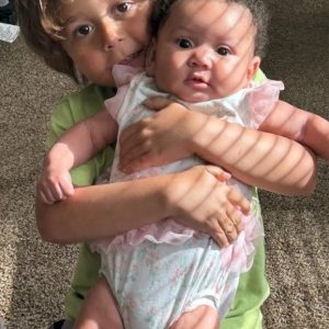 Tabetha Smith’s grandson holding his baby cousin, symbolizing hope for the next generation.
